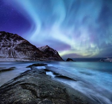 Kuzey ışığı yanar dağlar ve okyanus. Norveç'te güzel doğal peyzaj