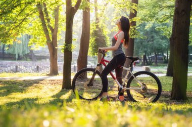 Kız parkta bisikletle. Spor ve fitness kavramı
