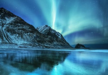 Aurora borealis Lofoten Adaları, Norveç. Dağlar yukarıda yeşil Kuzey ışıkları. Kutup ışıkları ile gece gökyüzü. Aurora ve su yüzeyinde yansıma ile gece kış manzarası. Norveç'te doğal arka plan