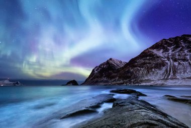 Aurora borealis Lofoten Adaları, Norveç. Dağlar yukarıda yeşil Kuzey ışıkları. Kutup ışıkları ile gece gökyüzü. Aurora ve su yüzeyinde yansıma ile gece kış manzarası. Norveç'te doğal arka plan