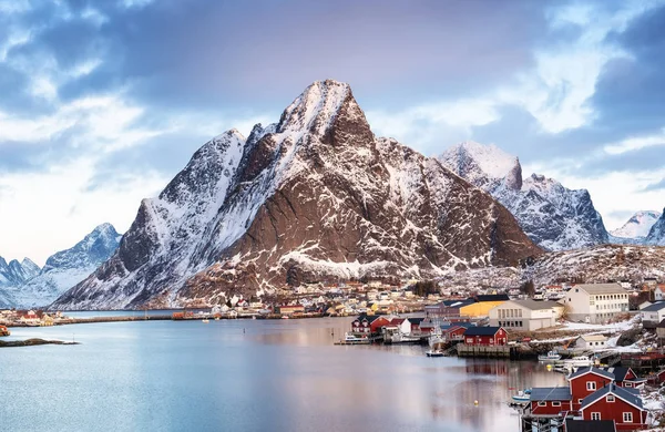 Mountains and sea bay on the Lofoten islands, Norway. Houses near mountains. Night winter landscape with mountains and town in the sea bay. Natural background in the Norway