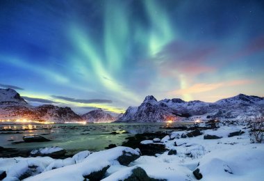 Aurora borealis Lofoten Adaları, Norveç. Dağlar yukarıda yeşil Kuzey ışıkları. Kutup ışıkları ile gece gökyüzü. Aurora ve su yüzeyinde yansıma ile gece kış manzarası. Norveç'te doğal arka plan