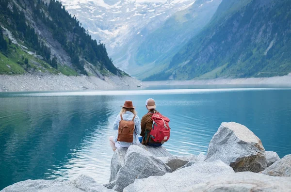出張カップルを見て山の湖 旅行やアクティブ ライフ コンセプト チームです 冒険やオーストリアの山岳地域で旅行 — ストック写真