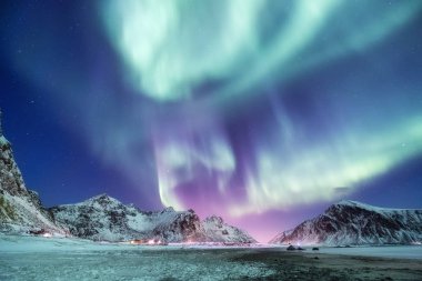 Aurora borealis Lofoten Adaları, Norveç. Dağlar yukarıda yeşil Kuzey ışıkları. Kutup ışıkları ile gece gökyüzü. Aurora ile gece kış manzarası. Norveç'te doğal arka plan