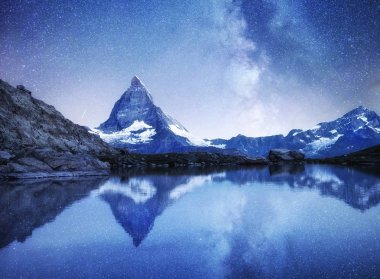 Matterhorn ve gece zaman su yüzeyinde yansıma. Matterhorn, İsviçre yukarıda Samanyolu. İsviçre güzel doğal peyzaj