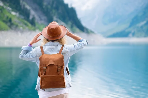 Traveler-Image. Traveler look at the mountain lake. Travel and active life concept. Adventure and travel in the mountains region in the Austria.