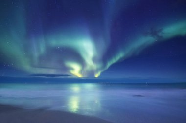 Aurora borealis Lofoten Adaları, Norveç. Okyanus üzerinde yeşil Kuzey ışıkları. Kutup ışıkları ile gece gökyüzü. Aurora ve su yüzeyinde yansıma ile gece kış manzarası. Norveç-görüntü