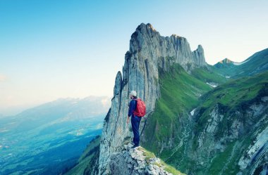Turist yüksek arka plan kayalar. Spor ve aktif bir yaşam kavramı. Macera ve İsviçre dağlarında dağ bölgesinde seyahat.