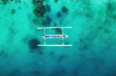 Üst görünümden su yüzeyinde tekne. Üst görünümden turkuaz su arka plan. Havadan yaz deniz manzarası. Gili Meno Adası, Endonezya. Seyahat-görüntü