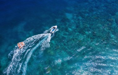 Endonezya, Bali 'de deniz yatları. Güneşli bir günde şeffaf turkuaz suda yüzen lüks teknenin havadan görünüşü. Havadan gelen yaz deniz manzarası. İHA 'nın üst görüntüsü. Koyda deniz botu olan bir deniz manzarası. Seyahat - resim