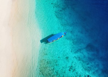 Üst görünümden su yüzeyinde tekne. Üst görünümden turkuaz su arka plan. Havadan yaz deniz manzarası. Gili Meno Adası, Endonezya. Seyahat-görüntü