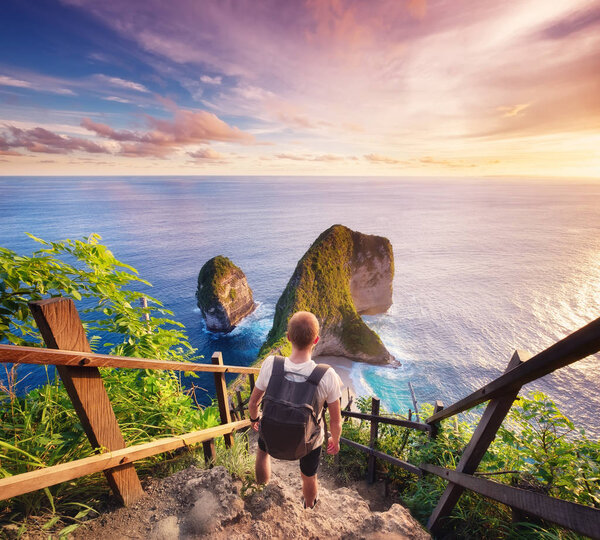 Traveler look at the ocean and rocks. Travel and active life concept. Adventure and travel on Bali, Indonesia. Travel - image