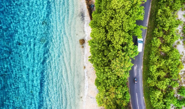 Aerial view on road in the forest. Highway throu the forest and sea coast. View from a drone. Natural landscape in summer time from air. Travel - image