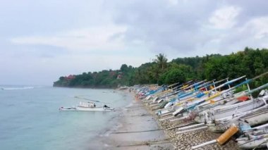 Endonezya, Bali 'de bir balıkçı teknesi. Güneşli bir günde şeffaf turkuaz suda yüzen teknenin havadan görüntüsü. İHA 'nın üst görüntüsü. Seyahat - Video