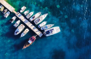 Akdeniz 'de. İHA 'dan marinaya bak. Güneşli bir günde mavi denizde yüzen teknenin havadan görüntüsü. Seyahat et ve rahatla - görüntü