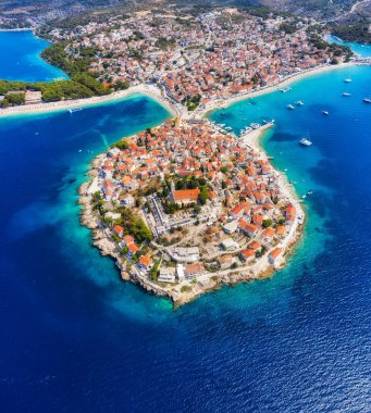 Primosten kasabası, Hırvatistan. Şehrin havadan görünüşü. Kumsalı ve eski kasabası olan bir deniz manzarası. Peninsula 'daki evlerle drone' un görüntüsü. Gün batımında manzara. Seyahat resmi