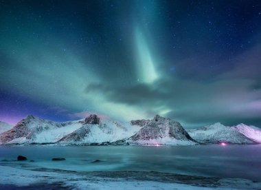 Norveç, Lofoten adalarında Aurora borealis. Dağların üzerinde yeşil kuzey ışıkları. Aurora ile gece kışı manzarası. Norveç 'te doğal geçmiş.
