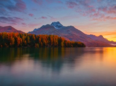 Doğa. Şafakta Dağ Gölü. Parlak gökyüzü ve bulutlar. Su yüzeyindeki yansımalar. Dağ vadisinin inanılmaz manzarası. Arkaplan, duvar kağıdı, kartpostallar için fotoğraf.
