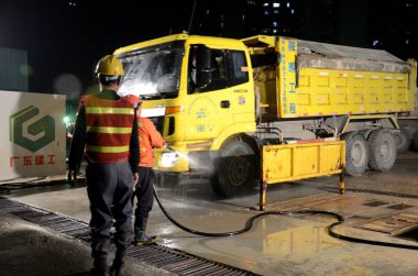 SHENZHEN, CHINA - APRIL 3: construction field in Futian district. Washing off truck in the night on April 3rd, 2018. clipart