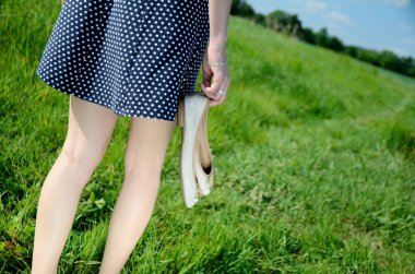 Erkek ile çıplak ayakla çimlerde yürüyor. Genç kadın açık yürüyüş, doğa, yeşil alanları ve mavi gökyüzü sahiptir.