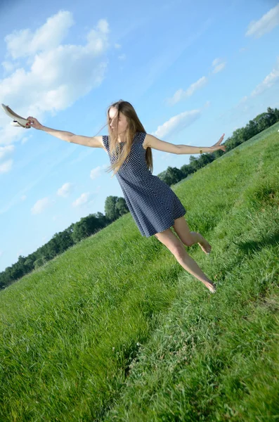 Çayır, çıplak ayak ve ayakkabı onun elinde yürüyen minyon kadın. Doğa ve özgürlük kollarını açarak kadın modeli sahiptir.