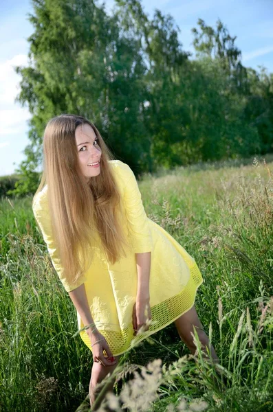 Маленькая Женщина Жёлтом Платье Позирует Лугу Высокой Травой Качестве Фона — стоковое фото