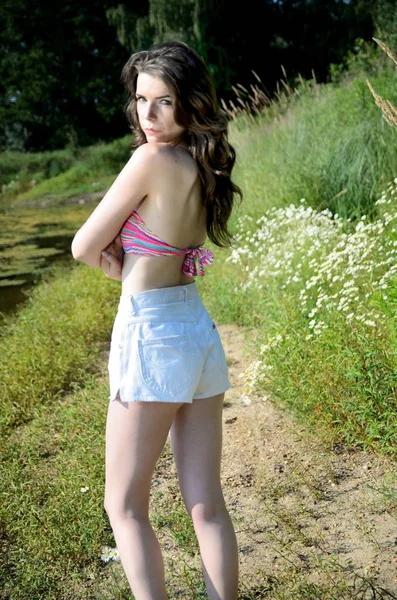 在波兰的户外摄影会上的年轻女性模特 女孩在短裤和比基尼顶部站立在湖附近 — 图库照片