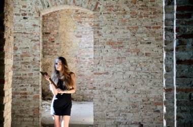 Kadın bir balta onun elinde tutan harabe durumda. Kalıntılar içinde siyah elbise, Polonya eski saray ile kadın modeli.