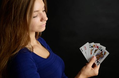 Genç kadın portre siyah arka plan ile. Beş poker kartları tutan kadın modeli.