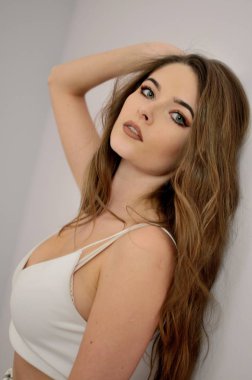 Duvara yakın duran çekici genç kadın portresi. Beyaz top ile su kuyusu-yapılı modeli. 