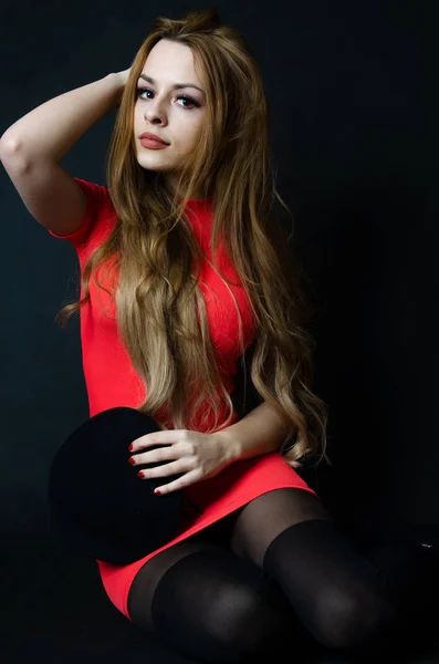 Kırmızı elbise ile dizlerinin üzerinde kız — Stok fotoğraf