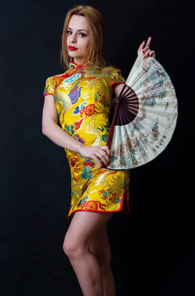 Menina caucasiana com vestido chinês e fã — Fotografia de Stock