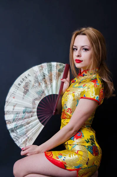 Menina caucasiana com vestido chinês e fã — Fotografia de Stock