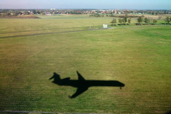 着陸中の飛行機の影 空港周辺の緑の草や強い影 平面の形状 ポーランドのヴロツワフ空港 — ストック写真