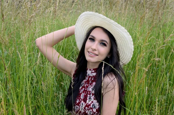美丽的女人带着夏帽在农村 年轻的波兰妇女被绿草环绕的画像 — 图库照片