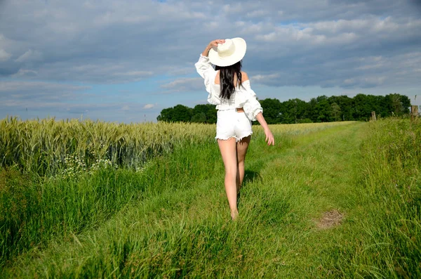 赤脚女孩走在绿草上 有帽子 白色短裤和白色上衣的女性 波兰的夏天 下西里西亚美丽的农田 — 图库照片