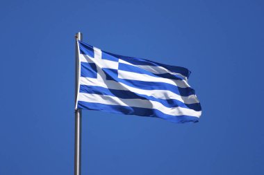 Güneşte bayrak direğinde Yunanistan bayrağı