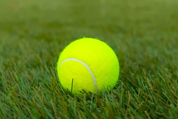 Pelota de tenis amarilla en césped artificial —  Fotos de Stock