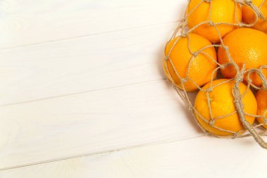 Portakallar bir torba dolusu jüt ipinde.