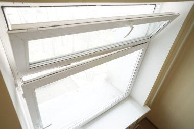 Beyaz cam pencere, beyaz arka planda havalandırma için açık.