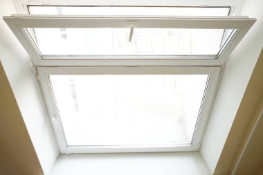 Beyaz cam pencere, beyaz arka planda havalandırma için açık.
