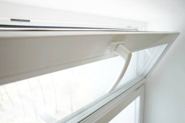 Beyaz cam pencere, beyaz arka planda havalandırma için açık.