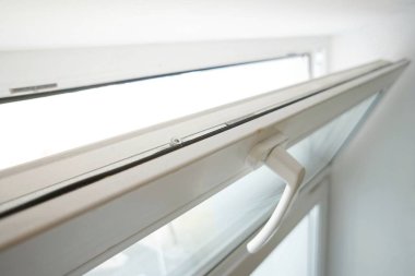 Beyaz cam pencere, beyaz arka planda havalandırma için açık.