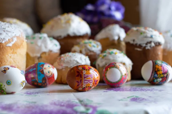 Easter handmade cakes or traditional Kulich and  painted eggs on kitchen table. Easter composition of sweet bread, paska and eggs. Russian orthodox tradition. Selective focus. Spring season.