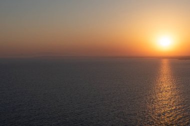Deniz de gün batımı. Ufkun üstündeki güneş. Son ışınlar.