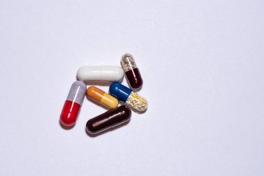 Renkli kapsüller. Beyaz arka planda haplar ve tabletler.