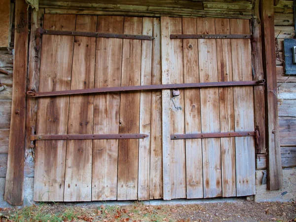 Large wooden doors of the old barn with iron canopies — Stock Photo, Image