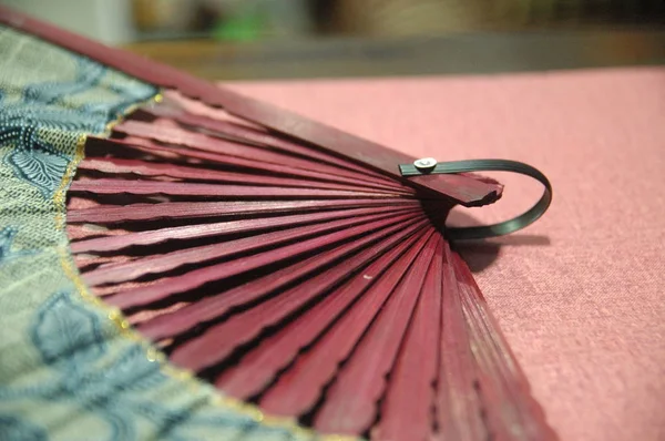 woman hand fan wooden red color close up