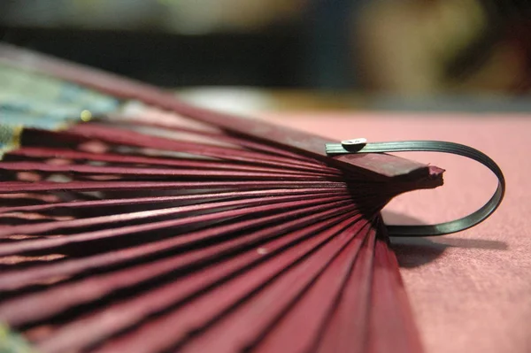 woman hand fan wooden red color close up