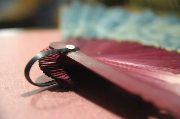 woman hand fan wooden red color close up